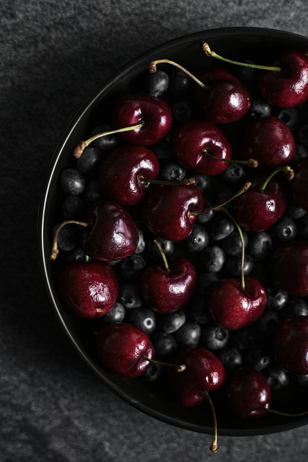 red cherries on stainless steel bowl