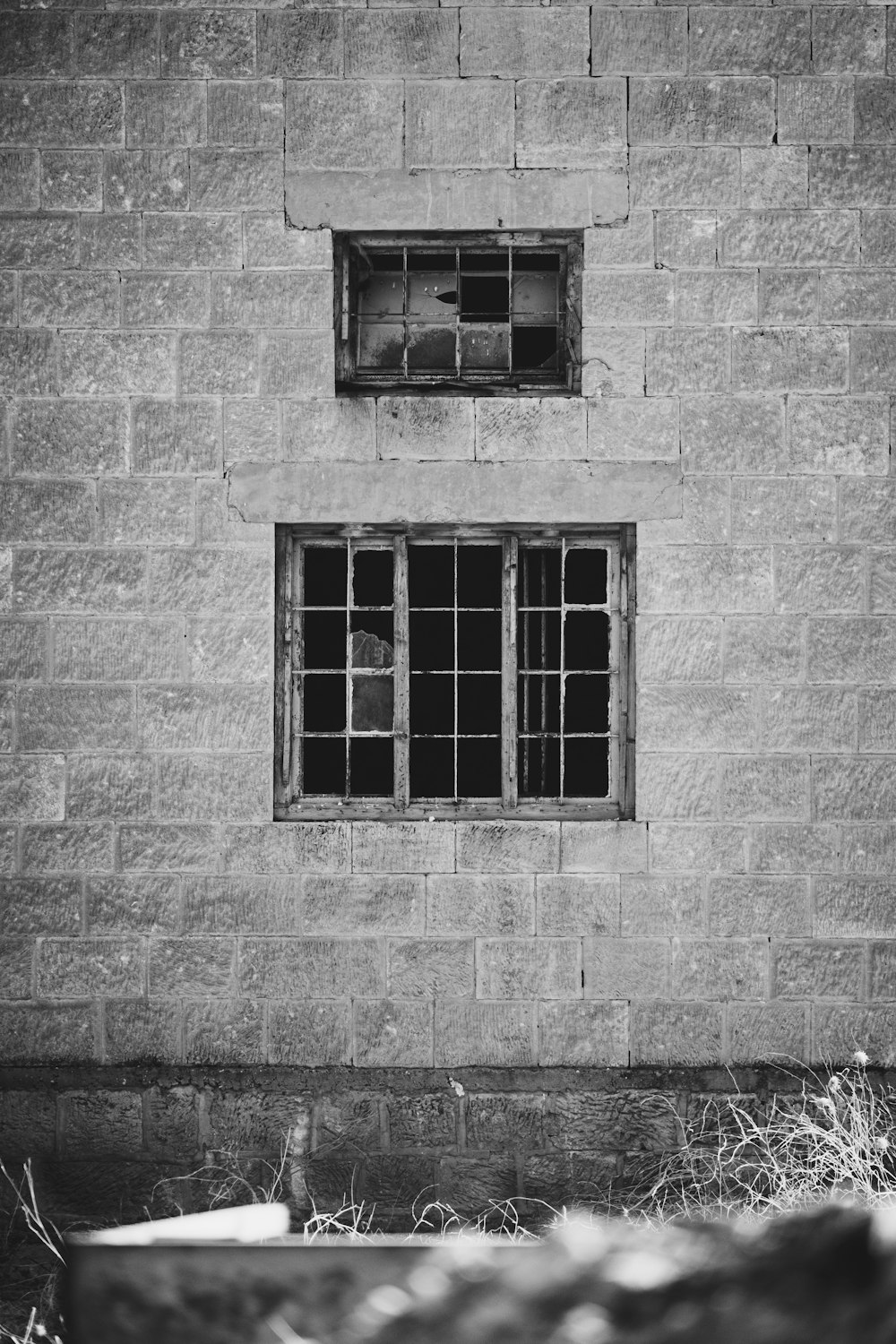 レンガの壁の窓のグレースケール写真