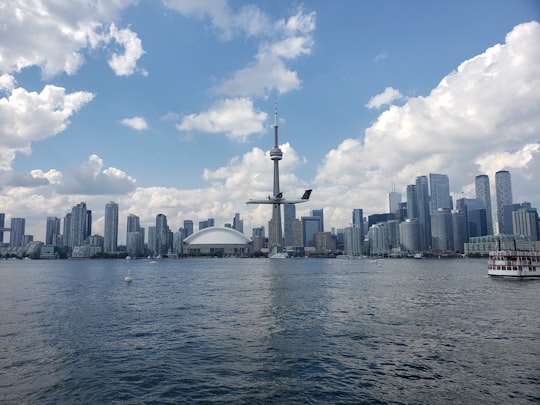 city skyline under blue sky and white clouds during daytime in CN Tower Canada