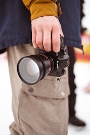 person holding black camera lens