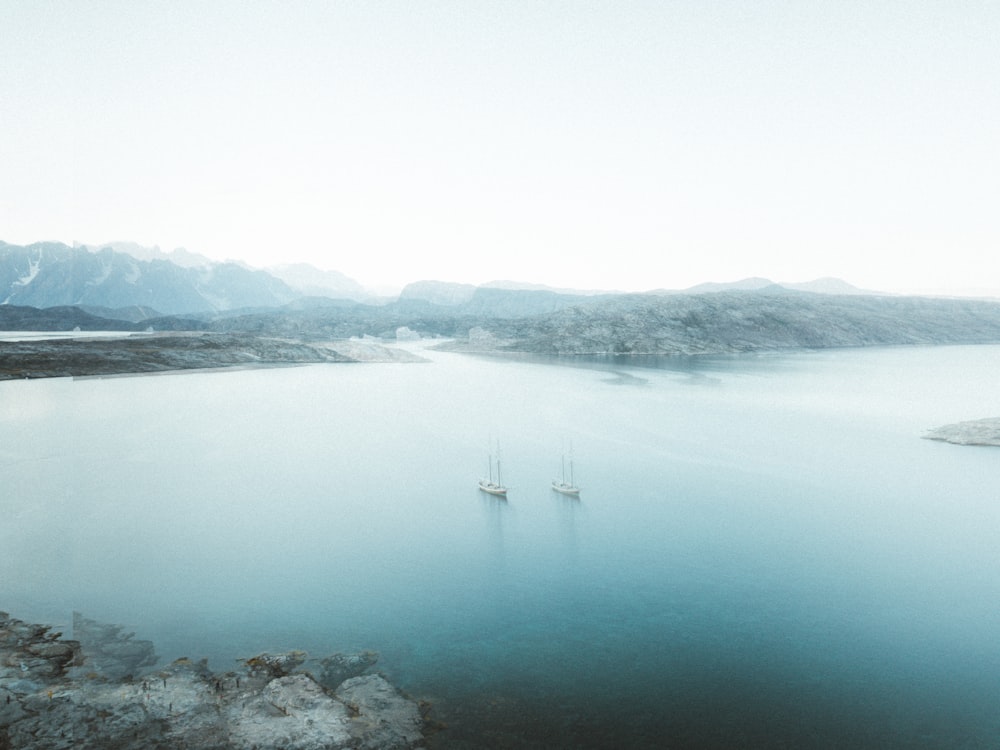 body of water near mountain during daytime