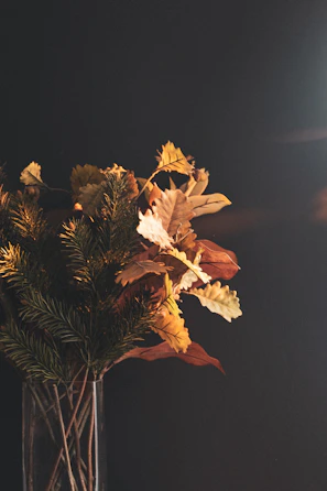 Seasonal wooden flower bouquet featuring autumn colors, set against a backdrop of fallen leaves.