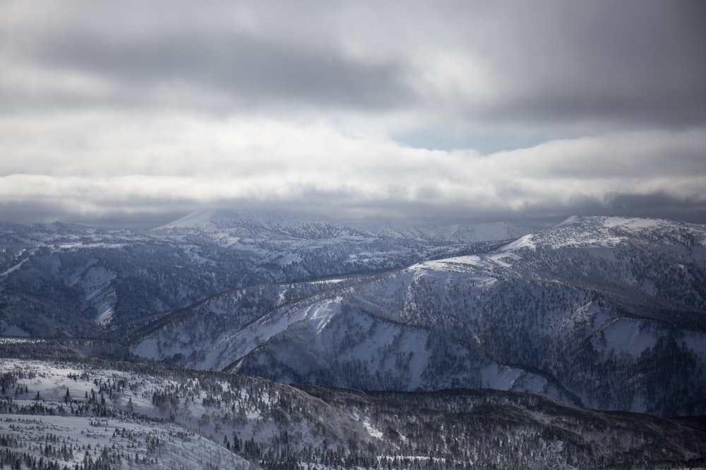 snow covered mountains under cloudy sky during daytime