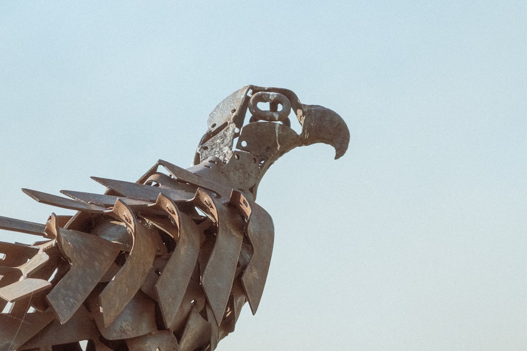 brown wooden bird statue under white sky during daytime