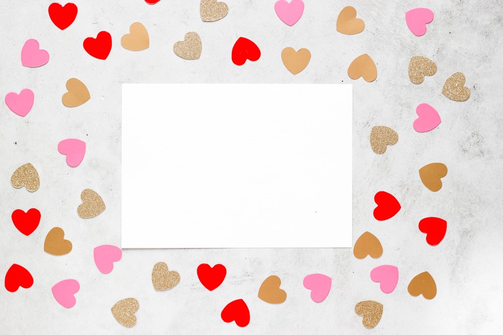 a white sheet of paper surrounded by hearts