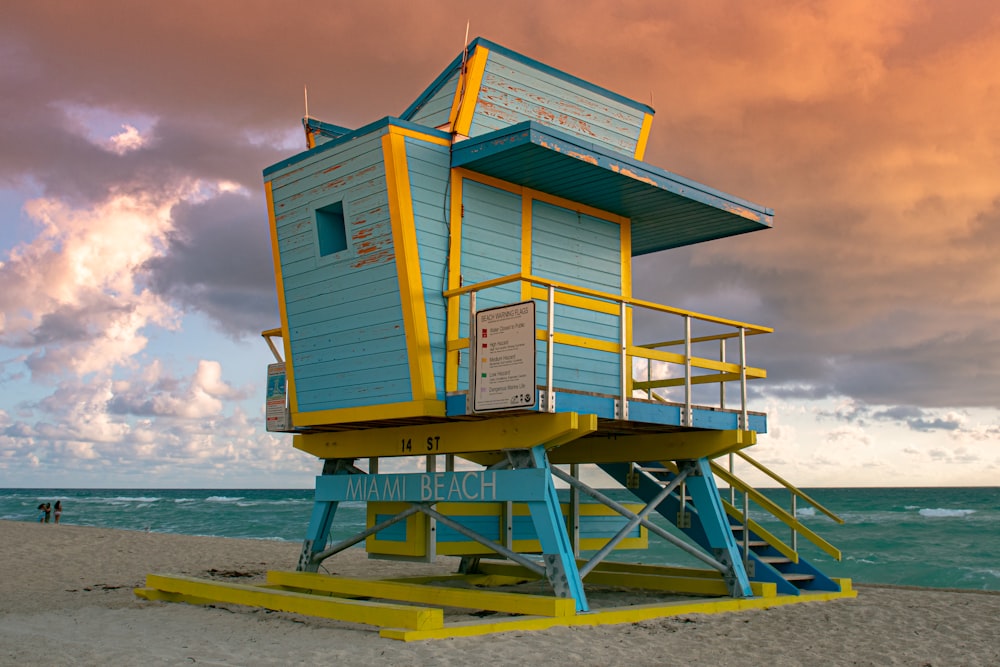 white and blue wooden lifeguard house on beach during daytime