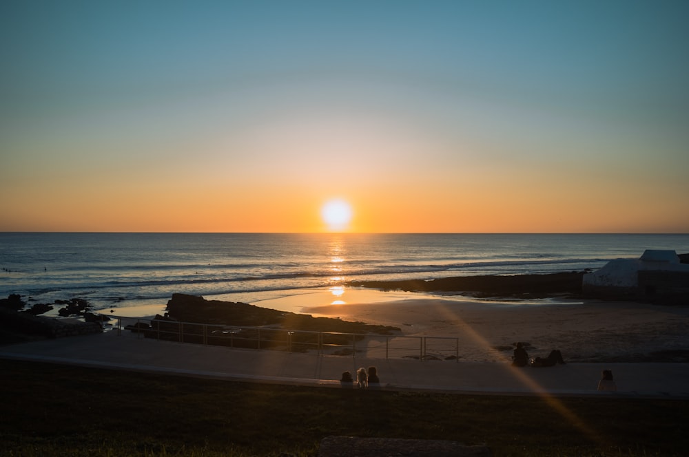 persone sulla spiaggia durante il tramonto