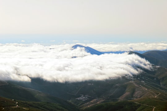 green mountains under white clouds during daytime in Serra da Estrela Portugal