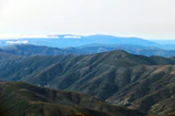 A wide angle view of a wind turbine farm with rolling green hills.