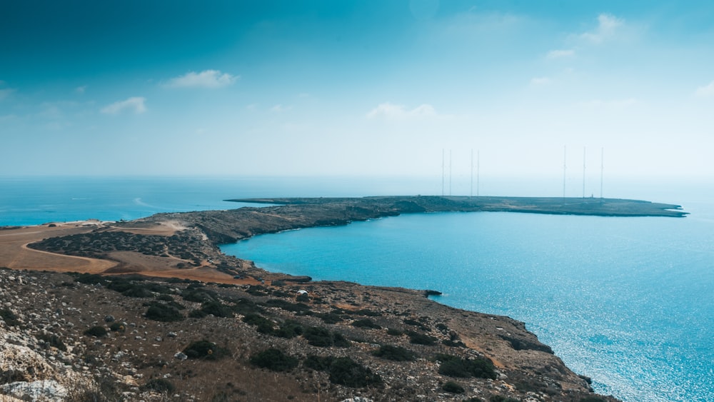 body of water near mountain under blue sky during daytime