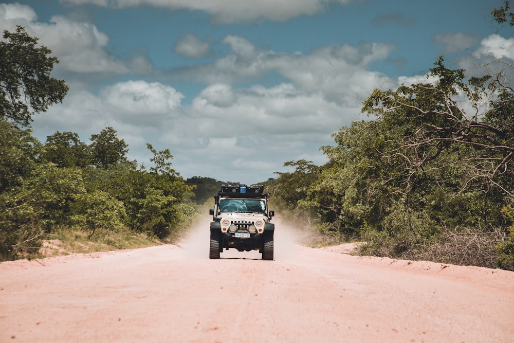 black suv on brown dirt road during daytime