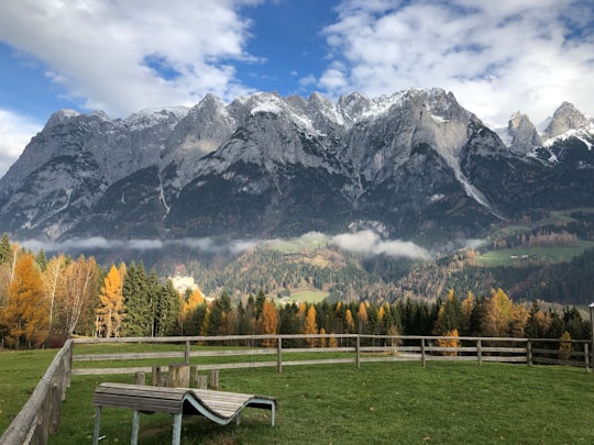 brown wooden bench near trees and mountain during daytime in Werfen Austria