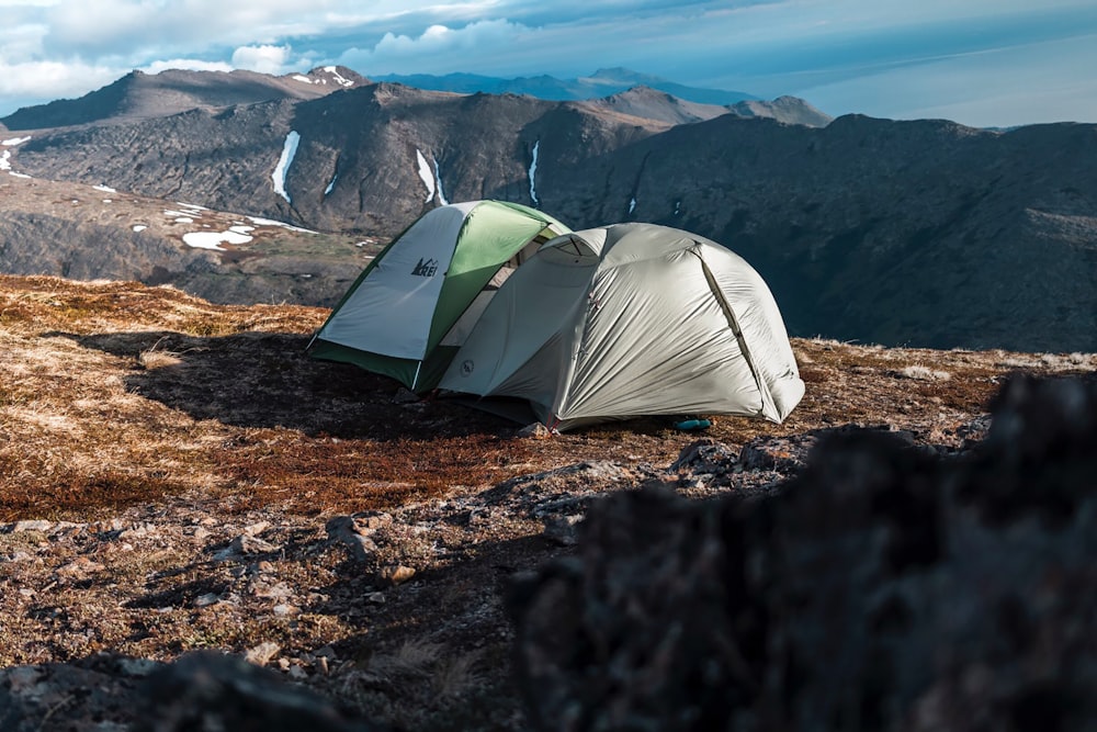 green and white tent on brown rocky mountain during daytime