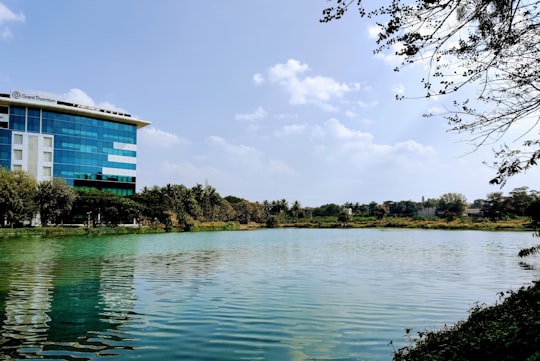 blue and white house near green trees and lake under white clouds and blue sky during in Bengaluru India