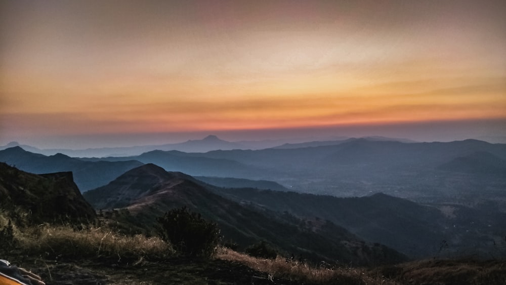 montagne sotto il cielo arancione durante il tramonto