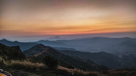 mountains under orange sky during sunset in Pune India