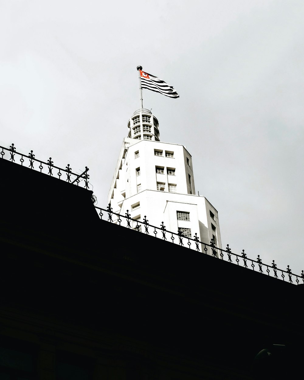 Una bandera en la parte superior de un edificio blanco