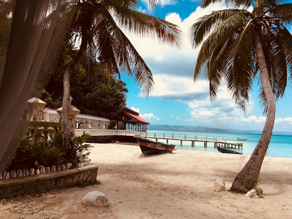 brown wooden boat on white sand near body of water during daytime