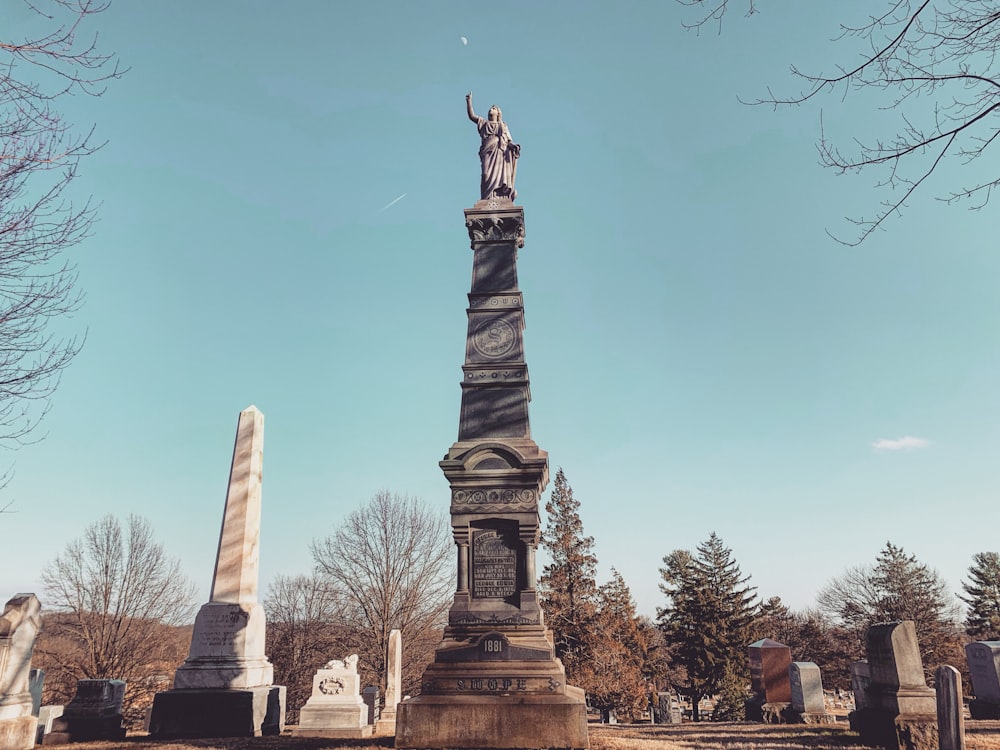 statue en béton brun sous le ciel bleu pendant la journée