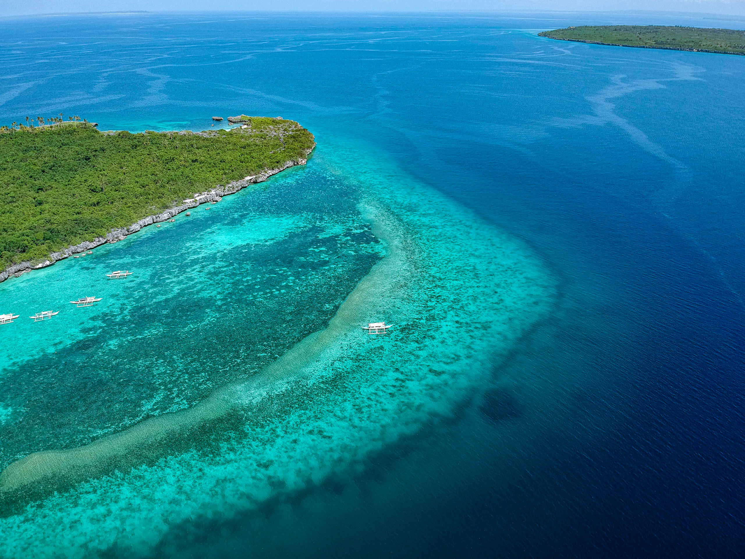 Bangka moored off a small island with a white-sand spit