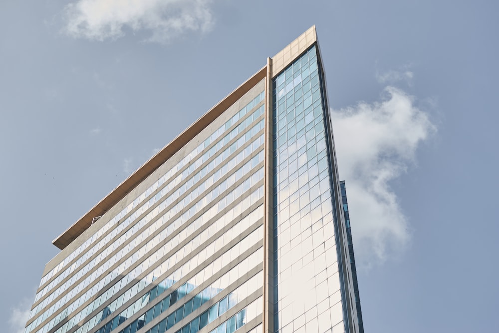 bâtiment aux murs de verre blanc et bleu sous le ciel bleu pendant la journée