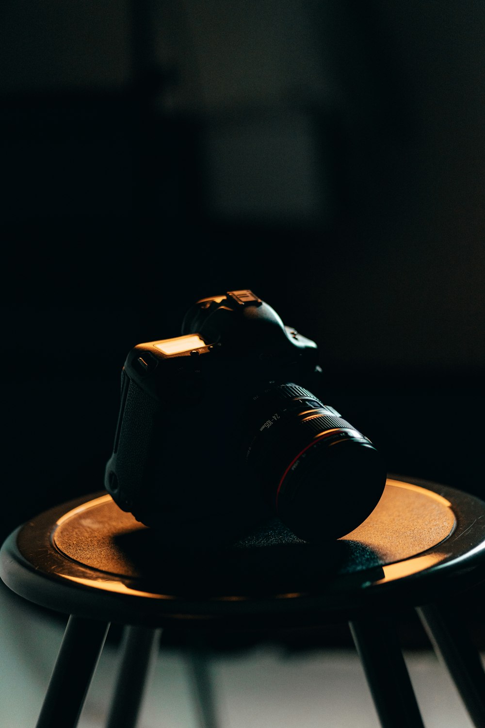Fotocamera DSLR nera su tavolo rotondo marrone