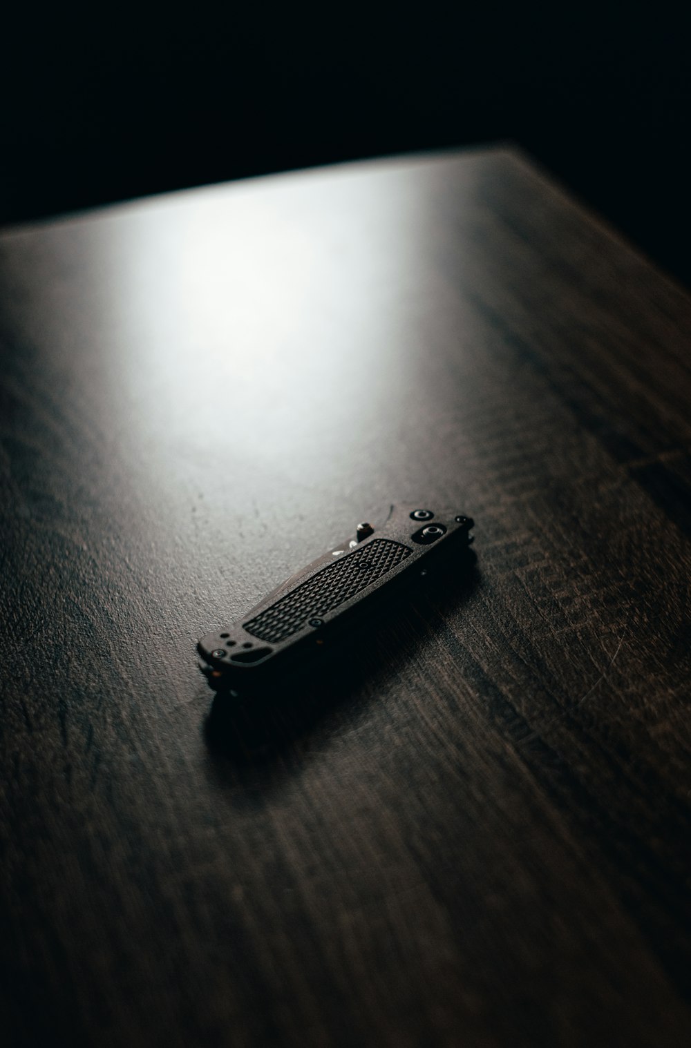 silver nail cutter on brown wooden table