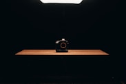 black point and shoot camera on brown wooden table