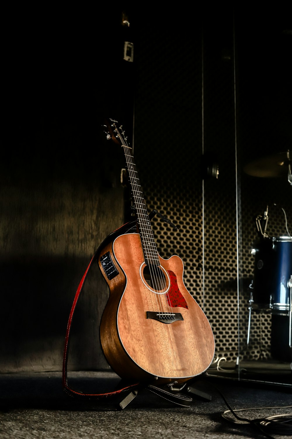 brown acoustic guitar on black guitar stand