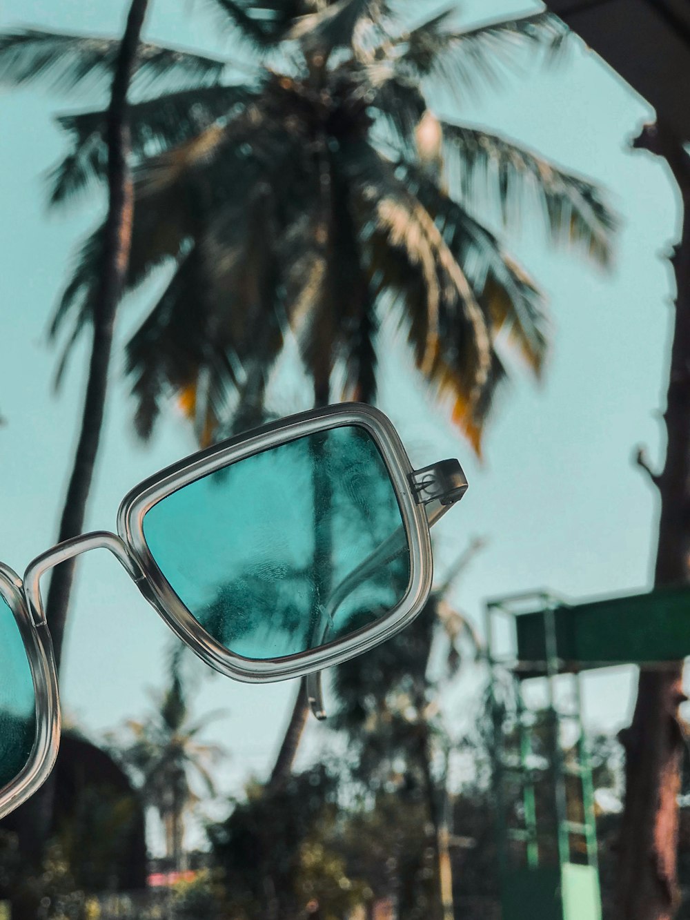 black framed eyeglasses on green wooden fence during daytime