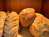 Freshly baked bread loaves arranged on a wooden table.