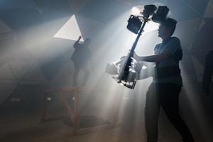 man in black t-shirt and black pants holding black dslr camera