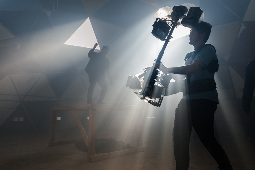 man in black t-shirt and black pants holding black dslr camera