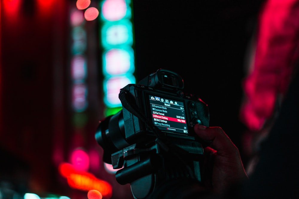 person holding black dslr camera