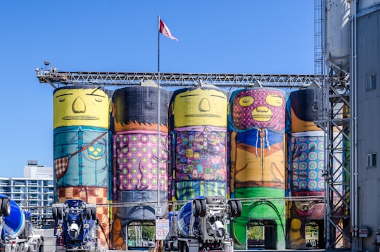 assorted flags on yellow concrete building during daytime in Stanley Park Canada