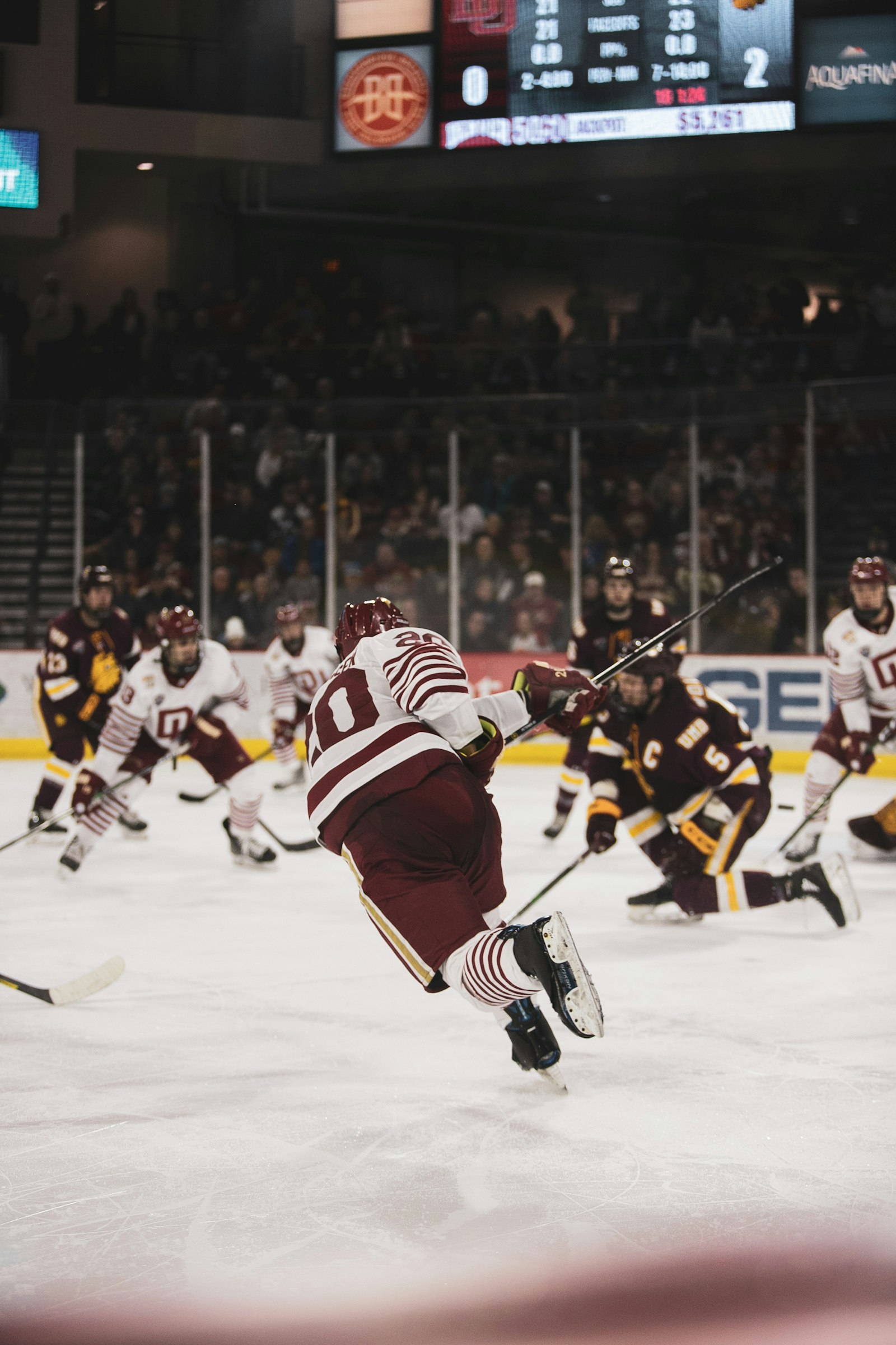 Ice hockey players battling along the boards under stadium lights — the kind of late-game shift where calf and hamstring cramps decide overtime.