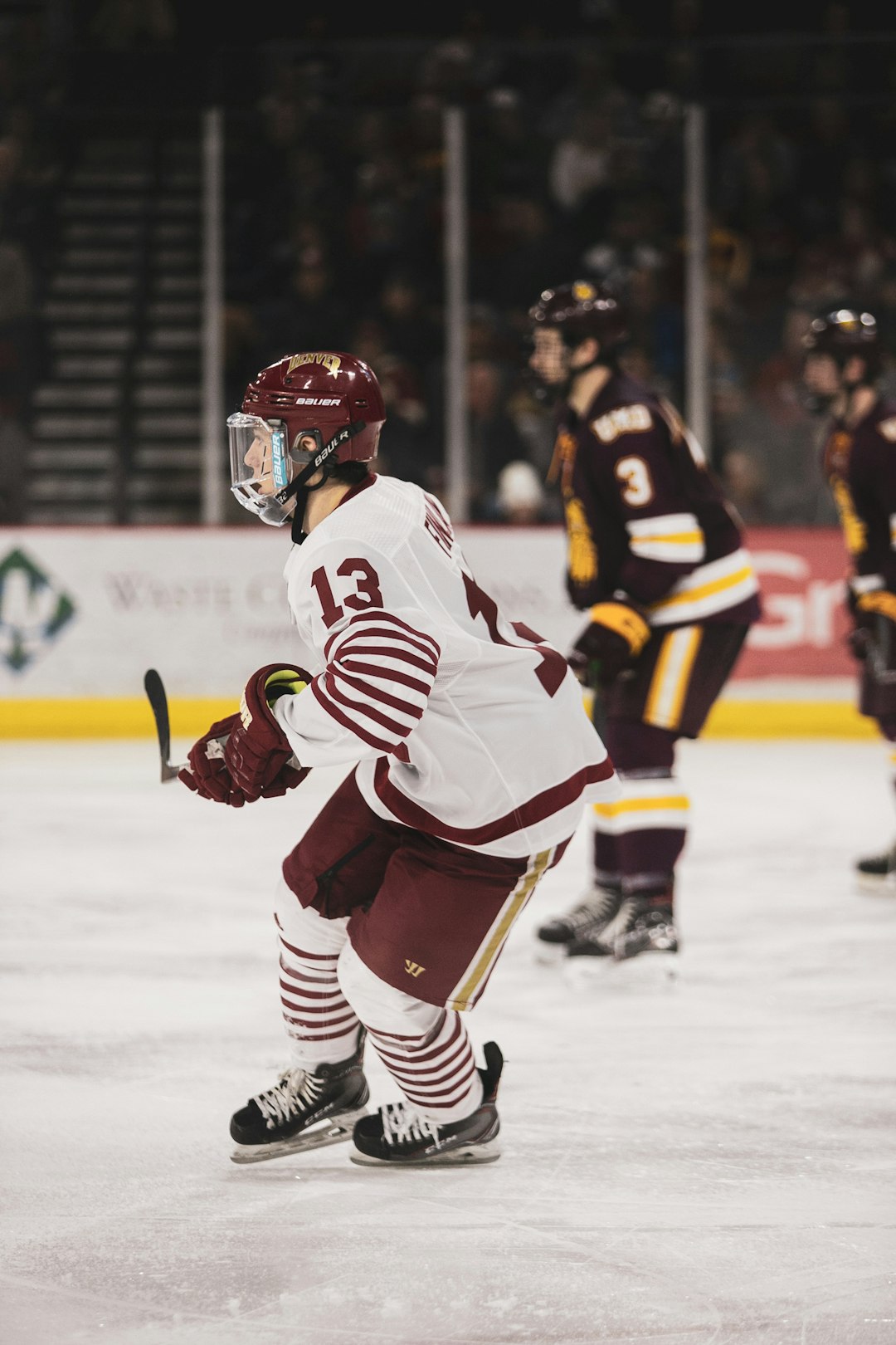 man in white and black ice hockey jersey playing ice hockey