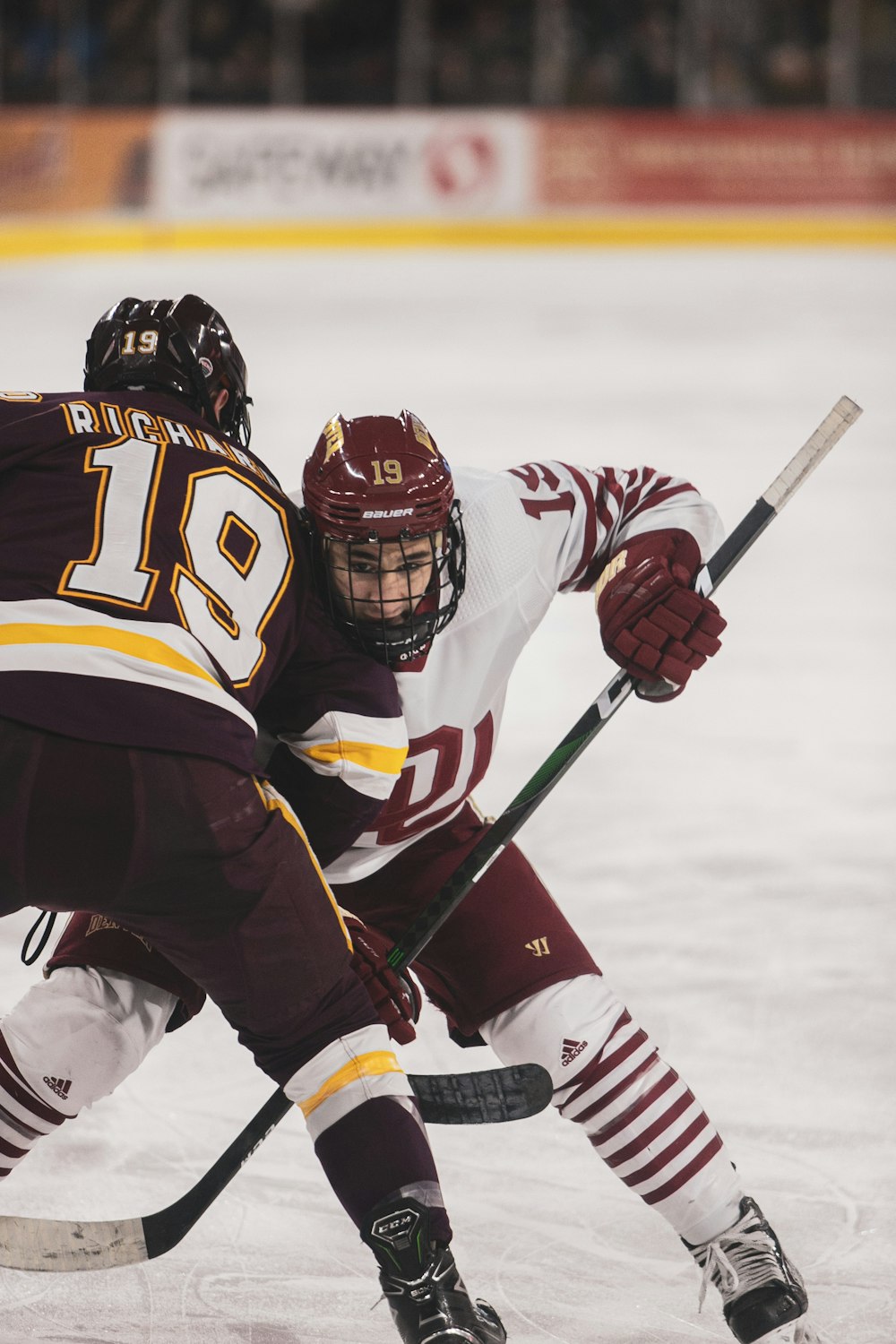 a couple of people playing a game of ice hockey