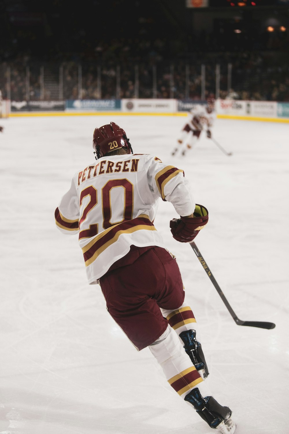 man in white and black ice hockey jersey playing hockey