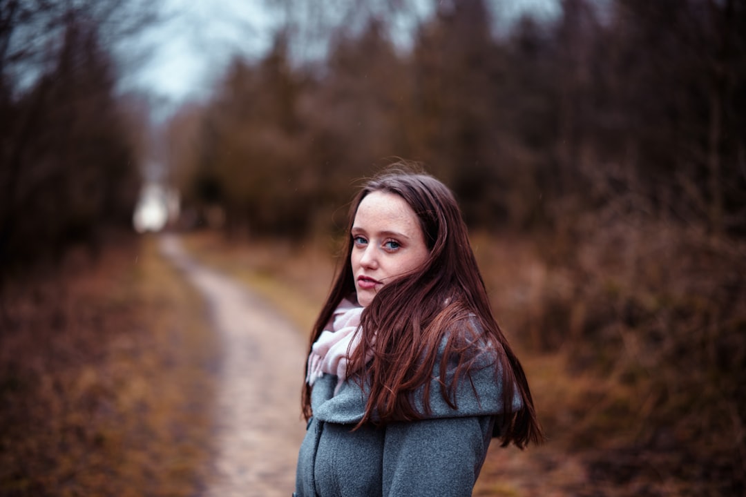 woman in blue denim jacket standing on road during daytime