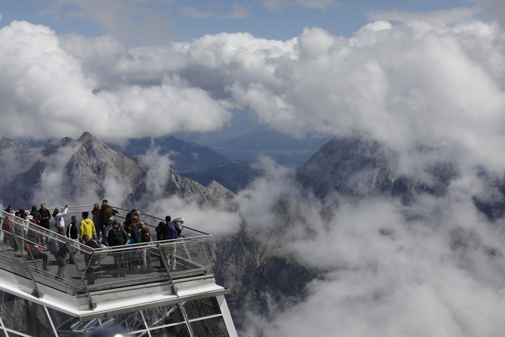 people riding on cable car under white clouds during daytime