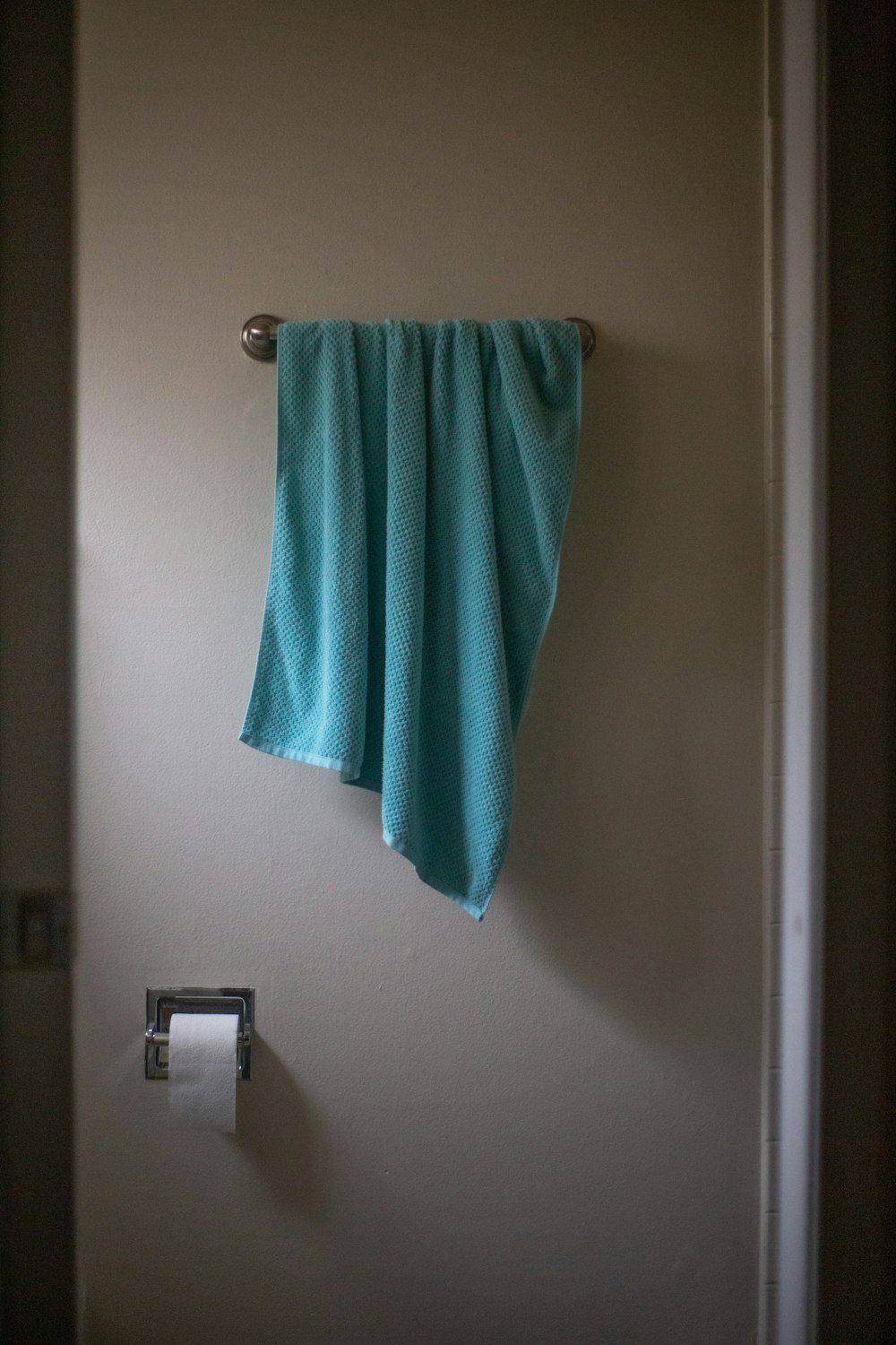 grünes Handtuch an weißer Wand