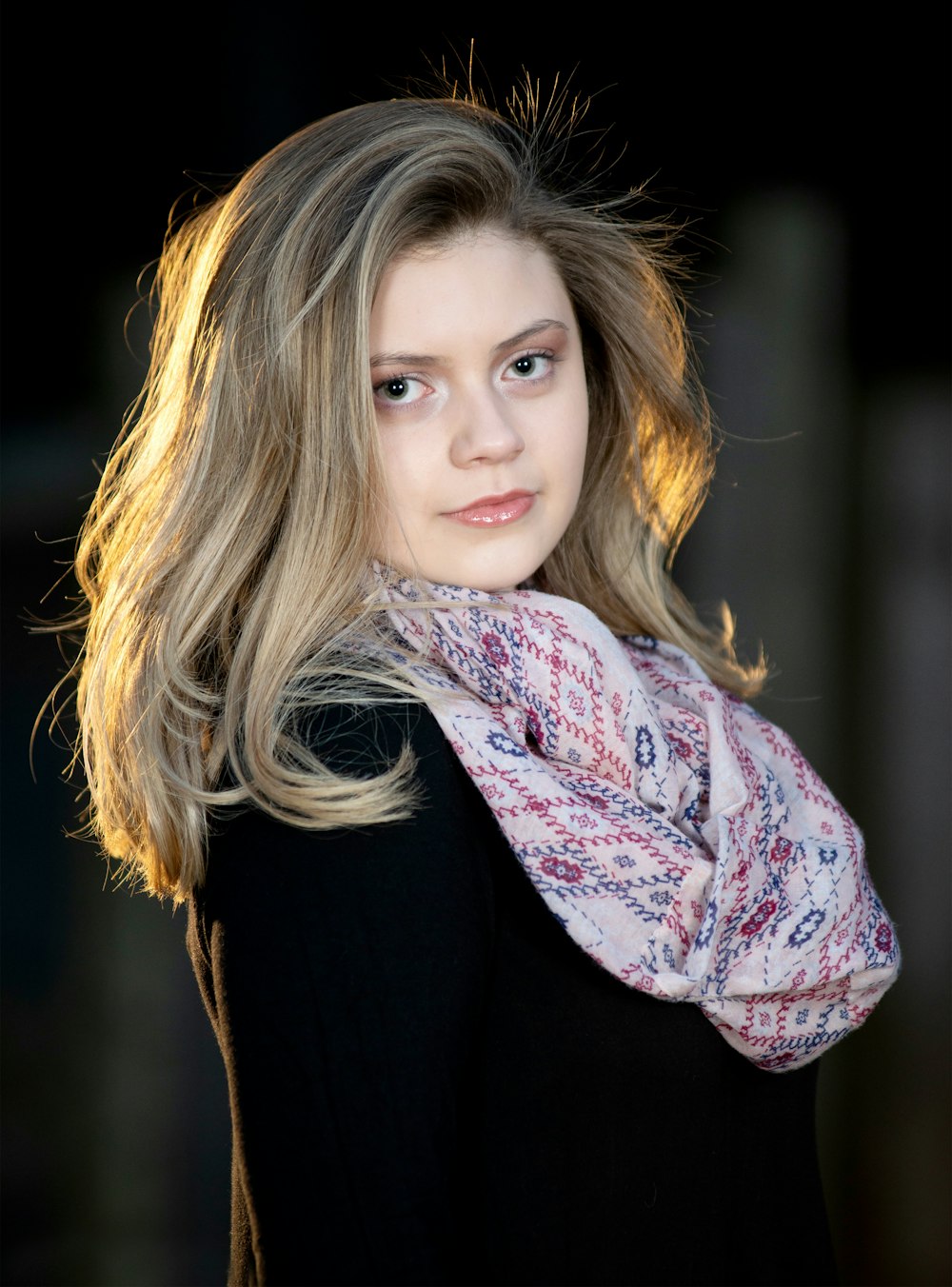 woman in black long sleeve shirt with white and pink scarf