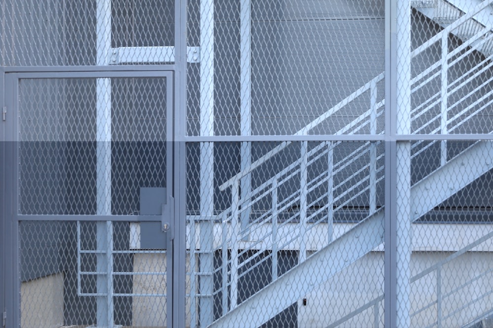 white metal fence near white building