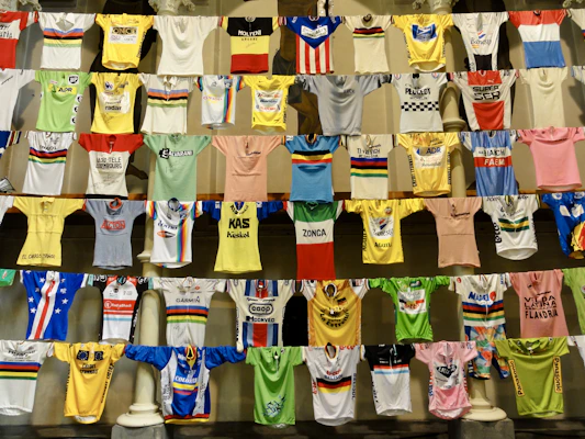 Display of retro-inspired women's jerseys hanging against a dark textured background.