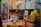A cluttered store shelf displaying a variety of packaged products, mostly health and body care items. There's a prominent sign labeled 'SEX SPRAY' among the assortment of Tiger Balm products and other colorful boxes stacked neatly. The background is lined with more items, creating a busy and tightly packed retail environment.