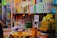 A cluttered store shelf displaying a variety of packaged products, mostly health and body care items. There's a prominent sign labeled 'SEX SPRAY' among the assortment of Tiger Balm products and other colorful boxes stacked neatly. The background is lined with more items, creating a busy and tightly packed retail environment.