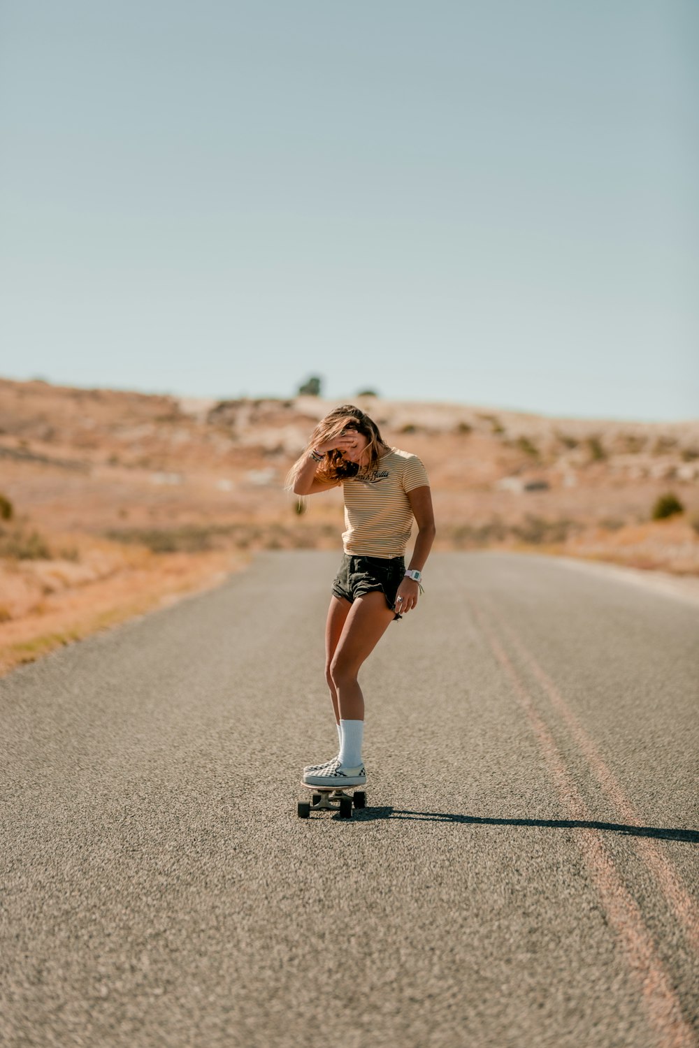 woman in white shirt running on road during daytime