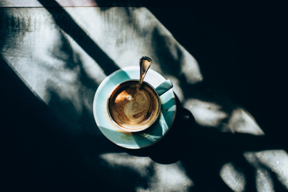 white ceramic cup with saucer on blue table