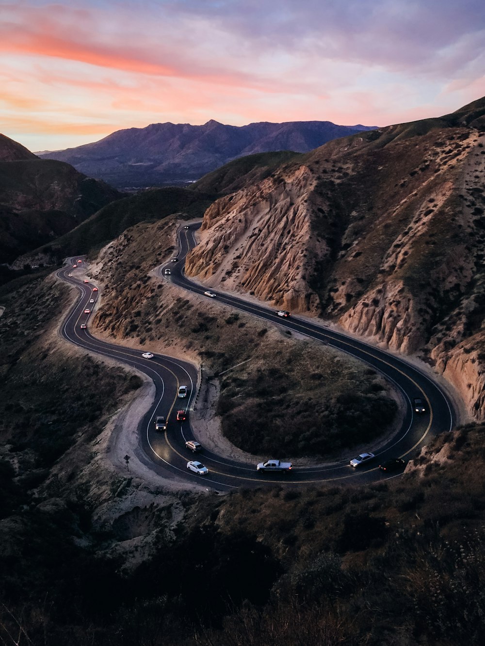 black asphalt road between brown mountains during daytime